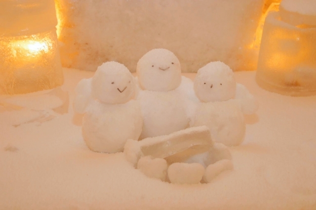 かまくらで暖まる雪だるまの写真